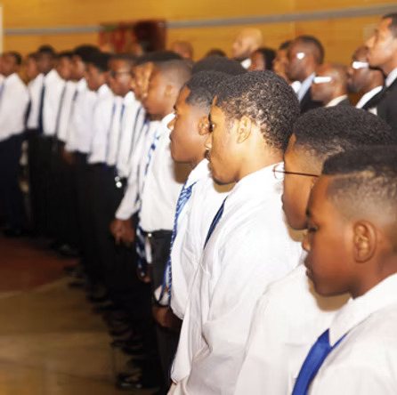 Young men in white shirts and blue ties standing in formation